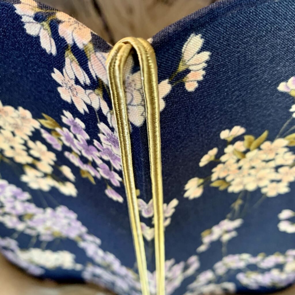 Détail couture et finitions textiles – Atelier Tissu & Lumière